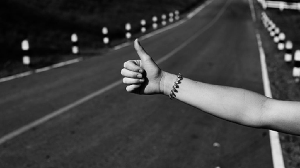 A hitchhiker with her thumb out.