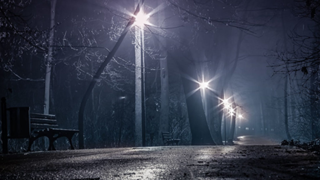 A foggy, empty street at night.